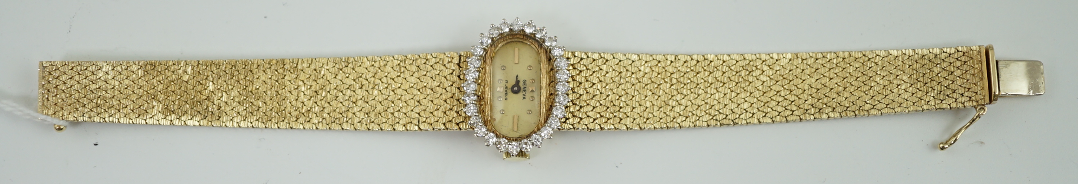 A lady's modern Swiss 14k gold and diamond set manual wind oval wrist watch, on integral 14k gold bracelet